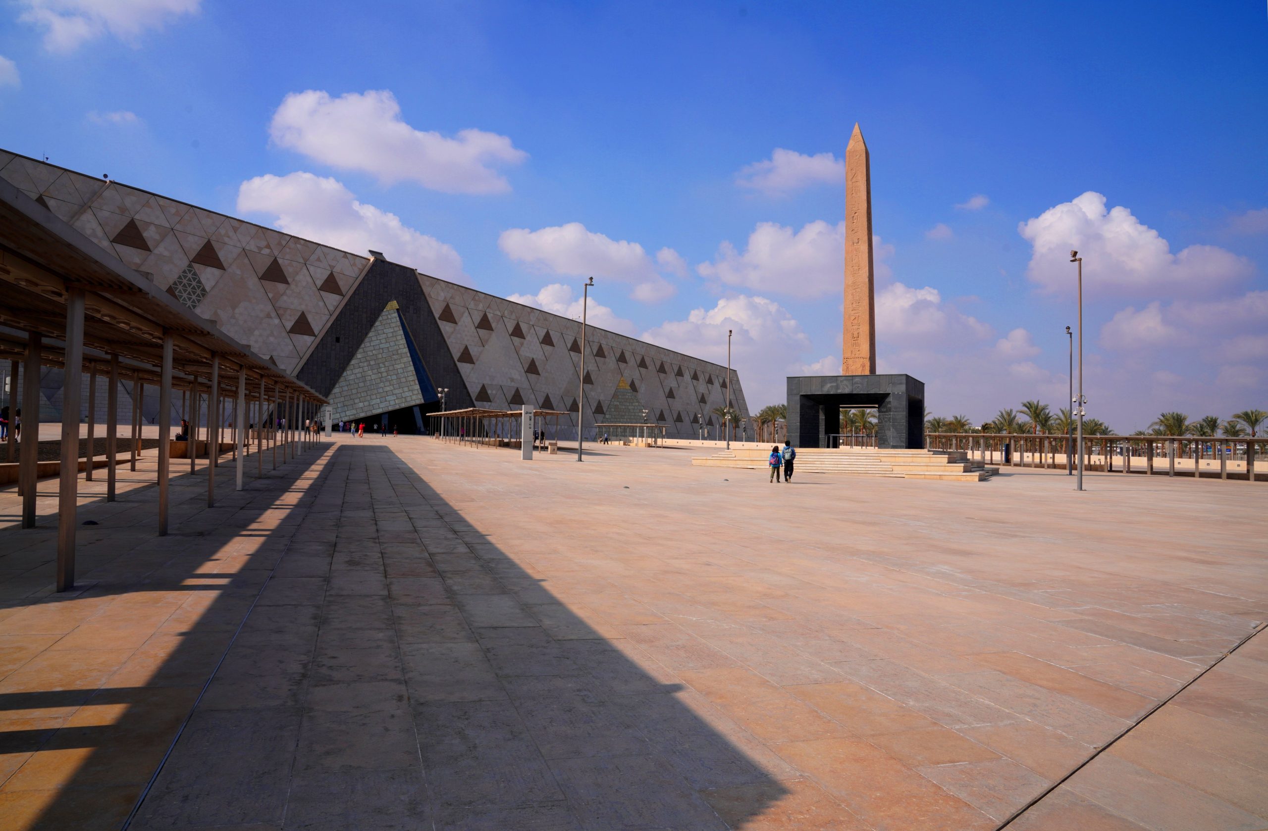 The Grand Egyptian Museum and the Historic Sites Worth Visiting on the Same Trip Wide-angle view of the Grand Egyptian Museum exterior with its obelisk beneath a clear sky.