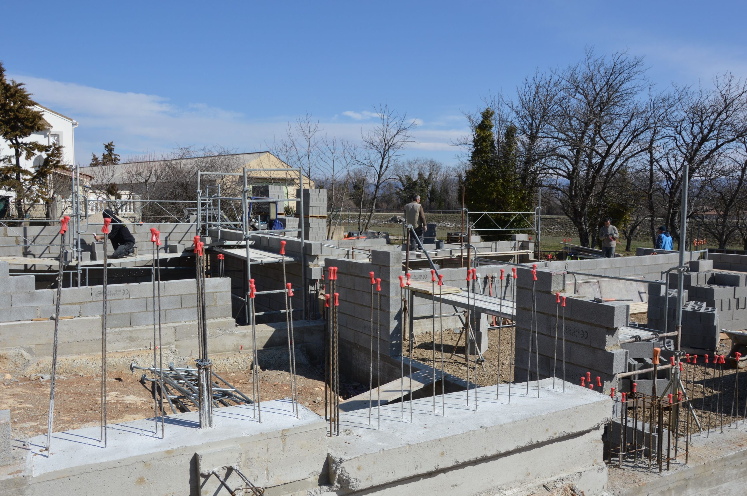 What Homeowners Should Expect Before and After a Home Elevation Workers build a concrete foundation at a residential construction site, illustrating the structural work involved in elevating a home.