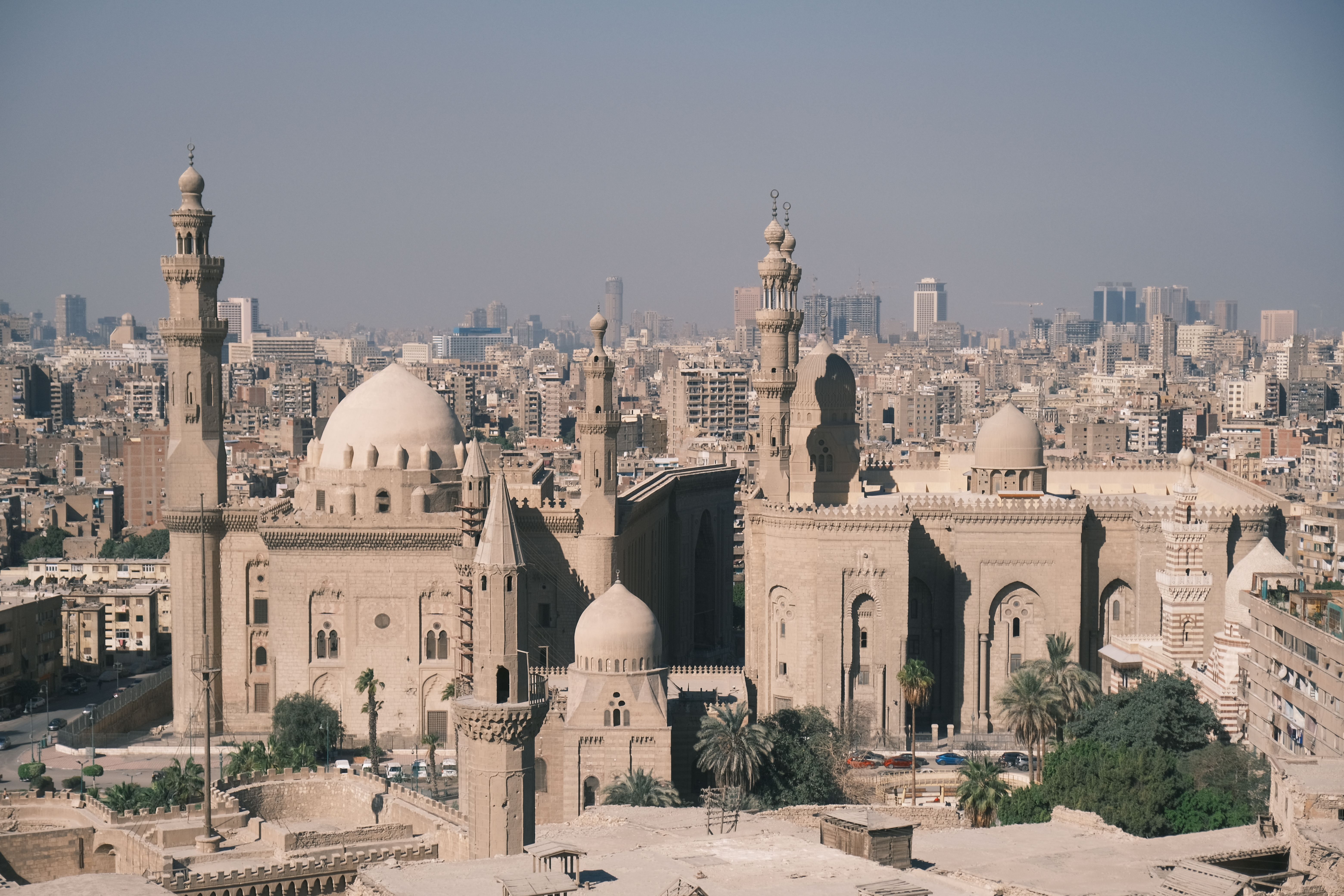 Aerial view of the historic Mosque-Madrassa of Sultan Hassan and Cairo skyline.